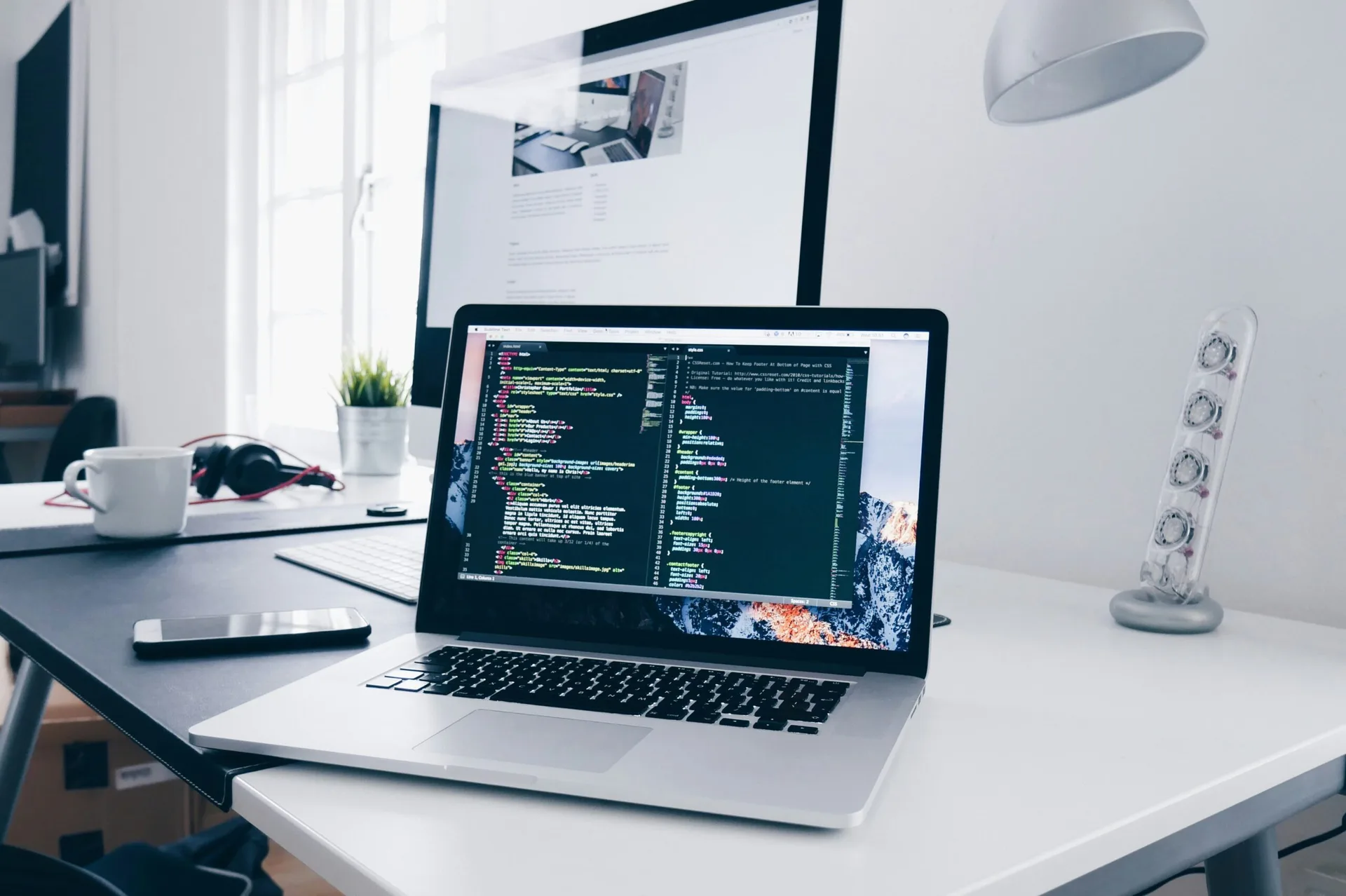 Laptop on an office desk with website code